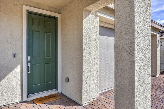 doorway to property featuring stucco siding