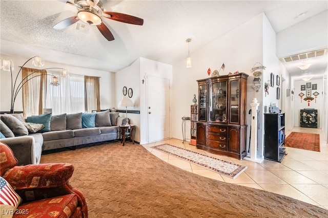 living room featuring light tile patterned floors, vaulted ceiling, a textured ceiling, and visible vents