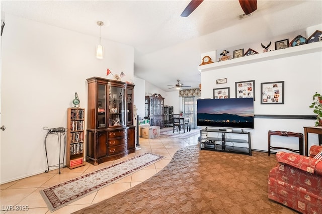 tiled living area with vaulted ceiling, visible vents, and a ceiling fan