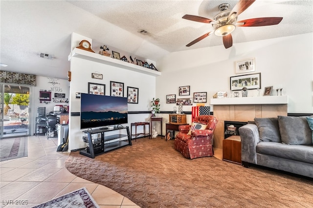 living room with visible vents, ceiling fan, tile patterned flooring, a textured ceiling, and a fireplace