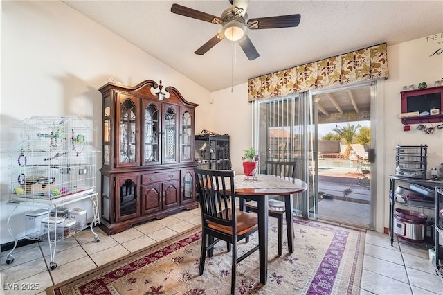 dining room featuring ceiling fan, vaulted ceiling, and light tile patterned floors