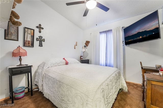 bedroom with lofted ceiling, ceiling fan, a textured ceiling, and dark colored carpet