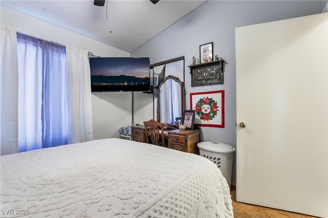 bedroom featuring vaulted ceiling, a textured ceiling, and a ceiling fan