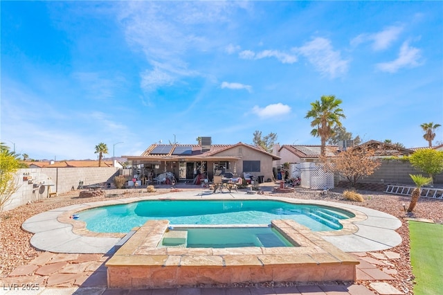 view of swimming pool with a fenced backyard, a fenced in pool, and an in ground hot tub