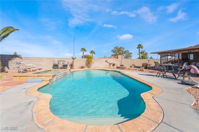 view of swimming pool featuring a fenced backyard, a pool with connected hot tub, and a patio