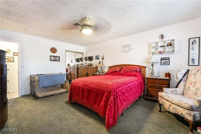 bedroom with visible vents, a textured ceiling, dark carpet, and a ceiling fan