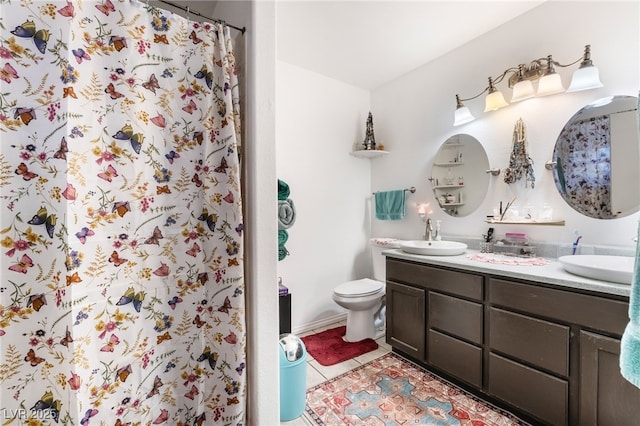 bathroom with double vanity, a sink, toilet, and tile patterned floors