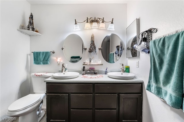 full bathroom featuring toilet, double vanity, and a sink