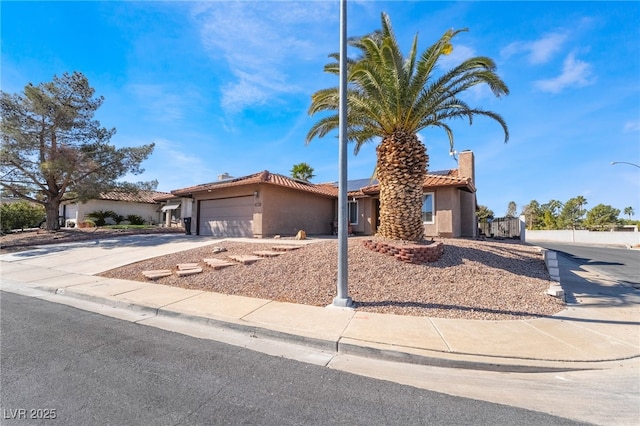 view of front of property featuring driveway, a tiled roof, an attached garage, and stucco siding