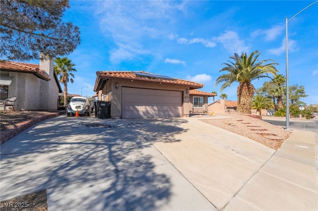 view of front of house with an attached garage, a tile roof, and stucco siding