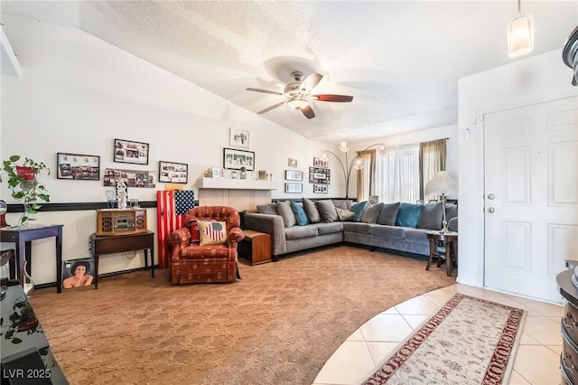 living area featuring light tile patterned floors, a textured ceiling, lofted ceiling, light colored carpet, and a ceiling fan