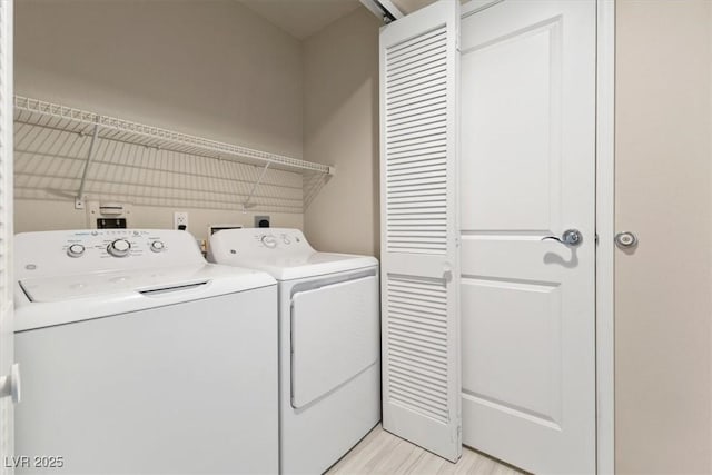 laundry room with light wood-type flooring, laundry area, and washing machine and clothes dryer