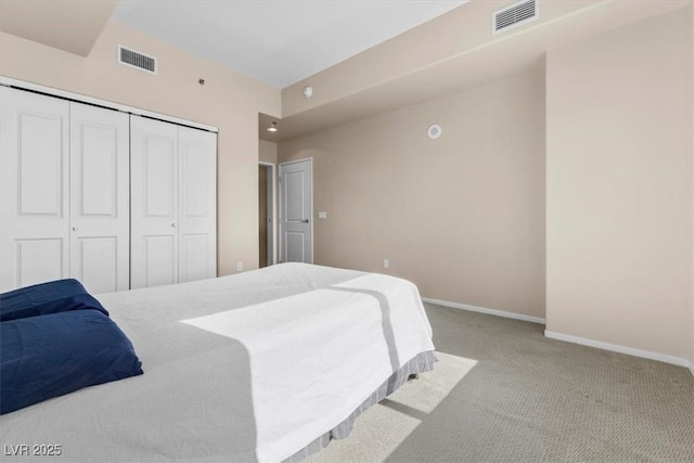 bedroom with light carpet, baseboards, visible vents, and a closet