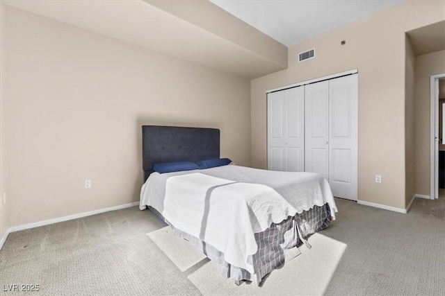 carpeted bedroom with a closet, visible vents, and baseboards