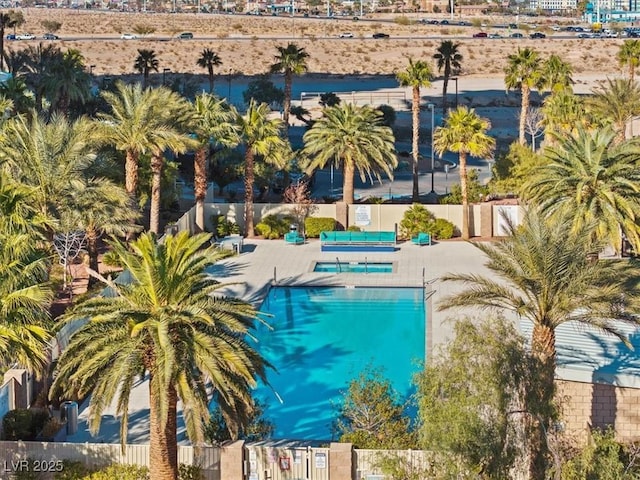 community pool with a patio area and fence