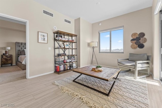 sitting room featuring light wood-style floors, baseboards, and visible vents