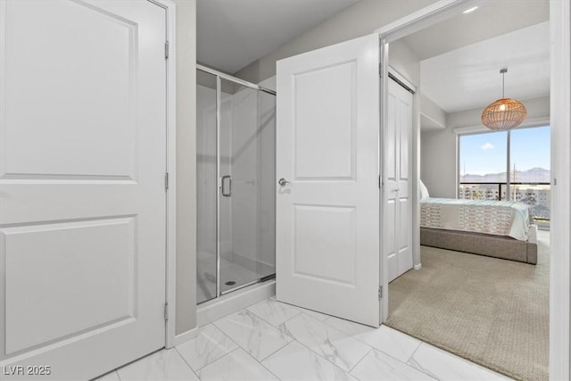 ensuite bathroom with marble finish floor, a shower stall, and ensuite bathroom