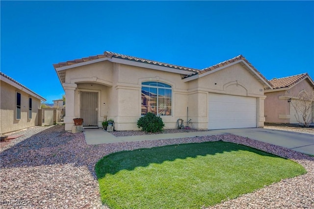 mediterranean / spanish-style house with a garage, driveway, a tiled roof, and stucco siding