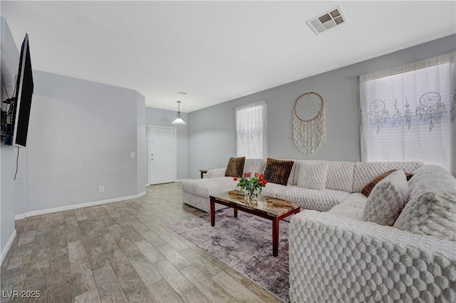 living area with light wood finished floors, baseboards, and visible vents