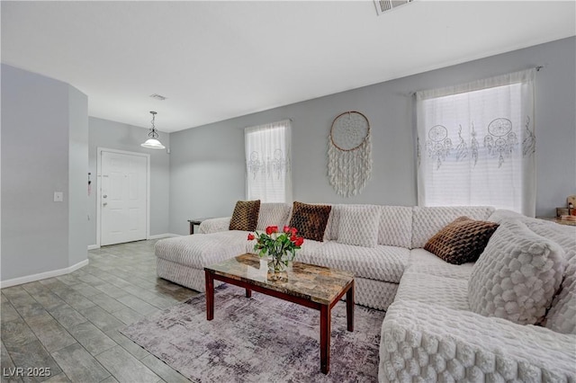 living area featuring light wood-type flooring, baseboards, and visible vents