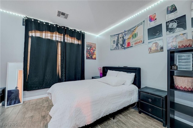 bedroom featuring visible vents and wood finished floors