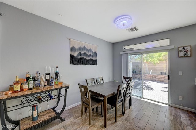 dining space featuring baseboards, visible vents, and wood finished floors