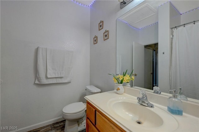 bathroom featuring baseboards, vanity, and toilet