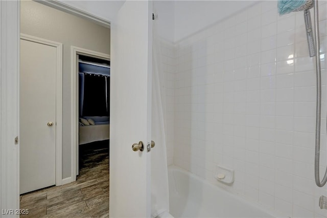 ensuite bathroom with shower / bathing tub combination, ensuite bathroom, and wood finished floors