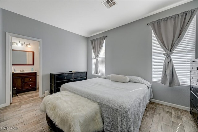 bedroom featuring light wood-type flooring, visible vents, and baseboards