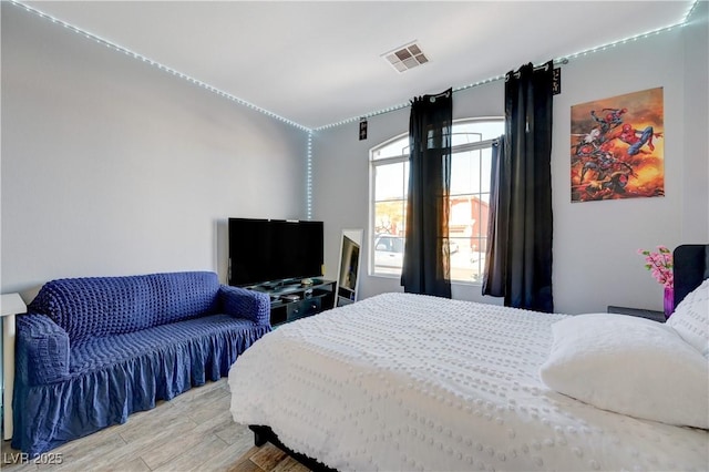 bedroom with light wood-style flooring and visible vents