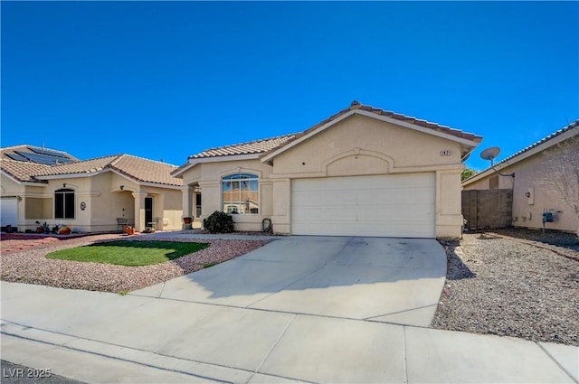 mediterranean / spanish house with stucco siding, solar panels, a garage, driveway, and a tiled roof