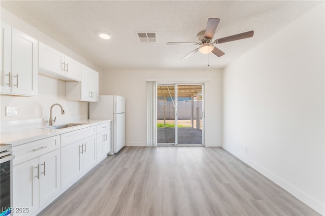 1817 Allen Ave, Henderson, NV 89011 - kitchen with light countertops, a sink, ceiling fan, freestanding refrigerator, and visible vents