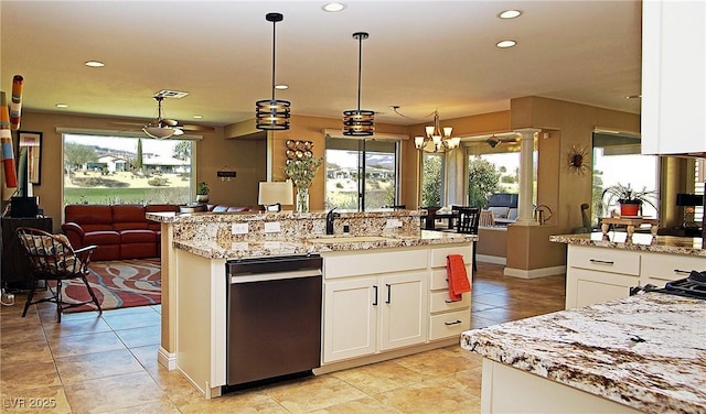 kitchen featuring recessed lighting, hanging light fixtures, white cabinetry, a sink, and an island with sink