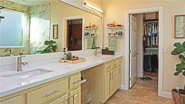 full bathroom featuring a sink, a spacious closet, and double vanity