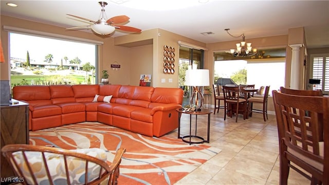 living room featuring ceiling fan with notable chandelier, visible vents, decorative columns, and light tile patterned floors