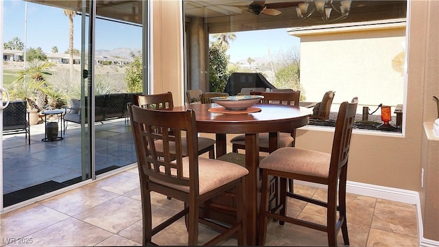 dining area featuring baseboards, light tile patterned floors, and a healthy amount of sunlight