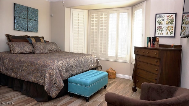 bedroom with light wood finished floors and baseboards