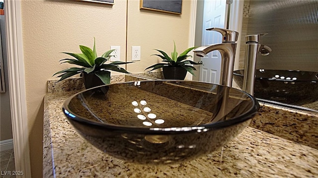 interior details featuring a textured wall and a sink