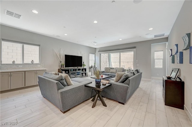 living room featuring recessed lighting, visible vents, and light wood-style floors