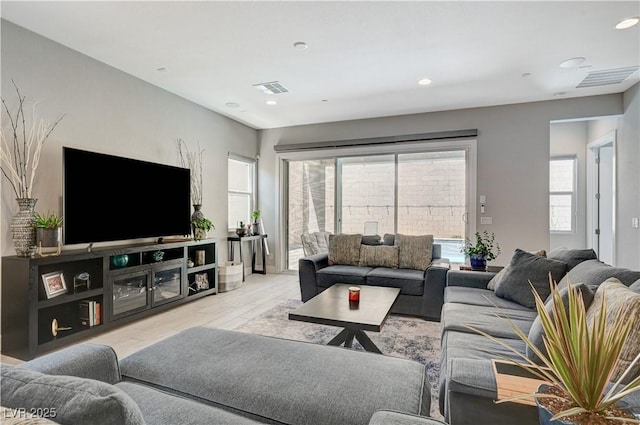 living area with recessed lighting, visible vents, and wood finished floors