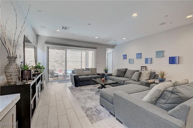 living room featuring wood tiled floor, visible vents, and recessed lighting