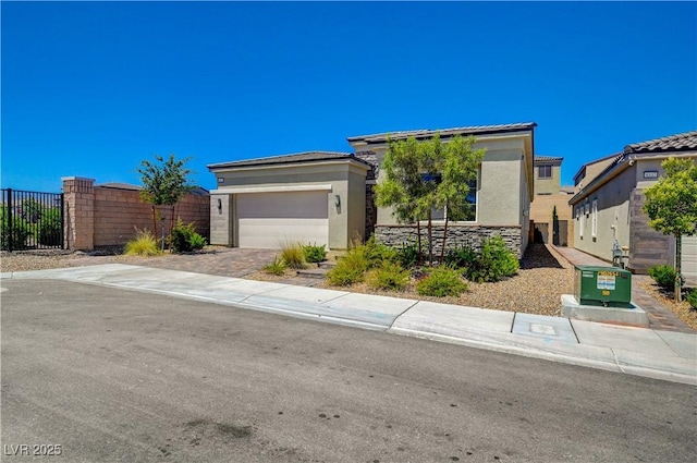 prairie-style house with stucco siding, central AC, fence, a garage, and driveway