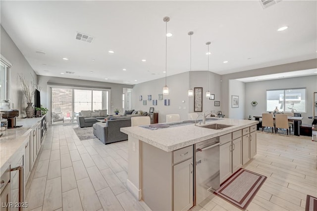 kitchen featuring a kitchen island with sink, a sink, visible vents, open floor plan, and dishwasher