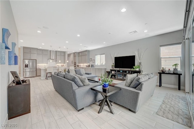 living area with visible vents, wood finish floors, and recessed lighting