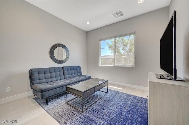 living room featuring baseboards, visible vents, and wood finished floors