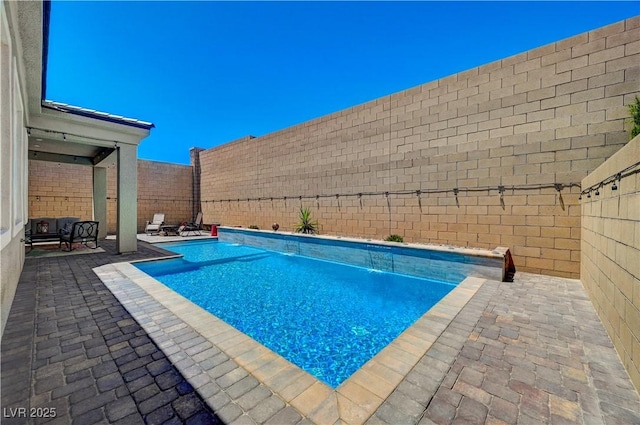 view of swimming pool featuring a fenced in pool, a fenced backyard, and a patio