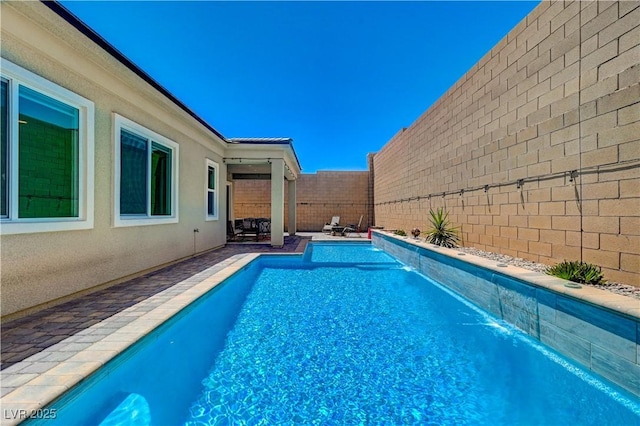 view of swimming pool featuring a patio, a fenced backyard, and a fenced in pool