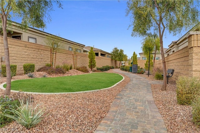 view of property's community featuring fence private yard and a yard