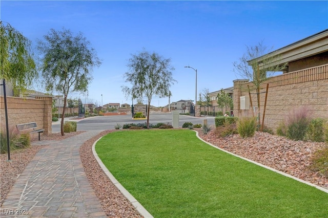 view of community featuring a residential view, a lawn, and fence