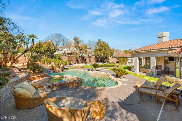 view of swimming pool with a lit fireplace, a patio, and an in ground hot tub